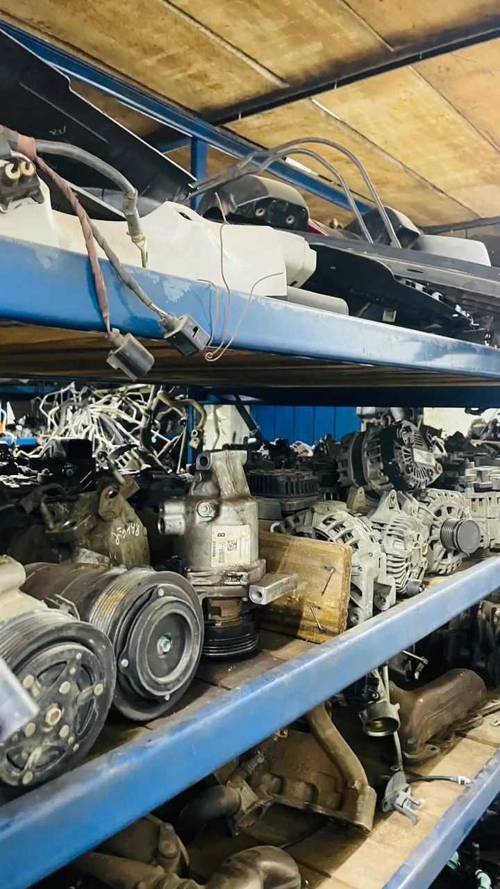 Componentes automotivos organizados em prateleiras azuis.
